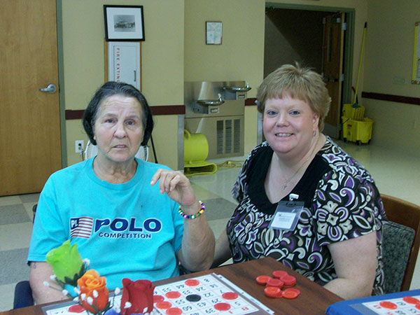 caregiver and resident playing bingo together